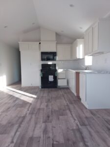 Five new homes have been delivered, each featuring an empty kitchen with wood floors and white appliances.