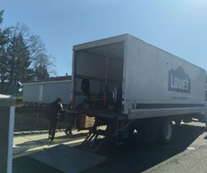 A moving truck is parked in a driveway surrounded by a total of 8 homes.