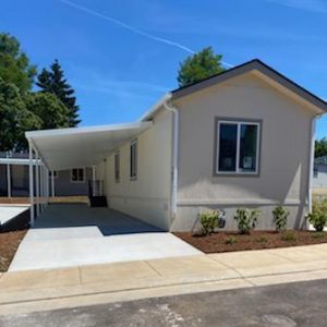 A mobile home with a covered parking area is part of the All 17 Homes Have Arrived at Clairmont development.