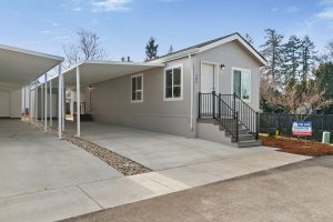 Mobile home with two garages and a driveway, designated as home #207.