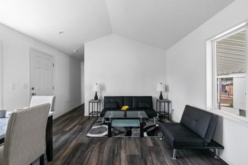 A living room with white walls and black furniture.