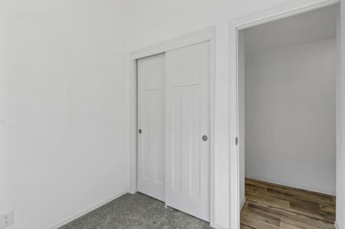 An empty room with white walls and a wooden floor.