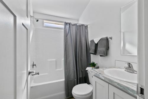 A white and gray bathroom with a toilet and sink.