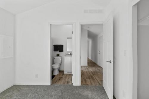 A bathroom with white walls and carpet.