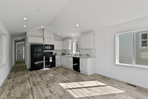 A white kitchen with wood floors and white appliances.