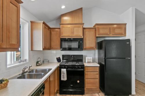 A kitchen with wood cabinets and black appliances.