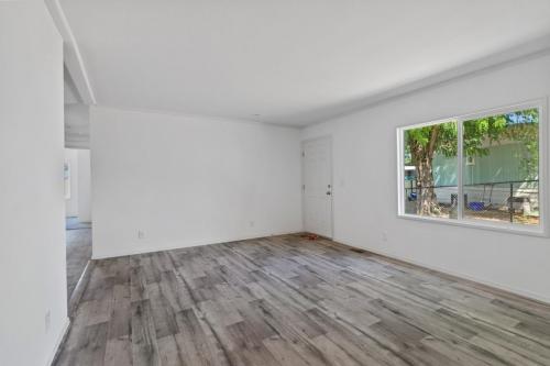 An empty room with wood floors and white walls.