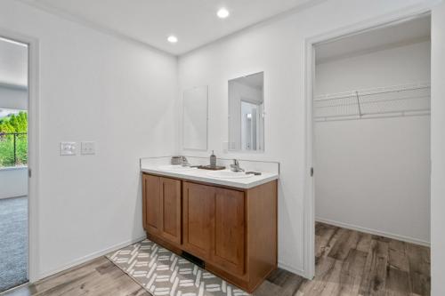 A white bathroom with wooden floors and a sink.