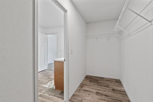 A closet with a wooden floor and white walls.