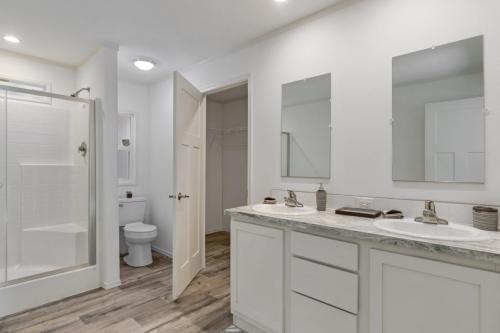 A white bathroom with a walk in shower.