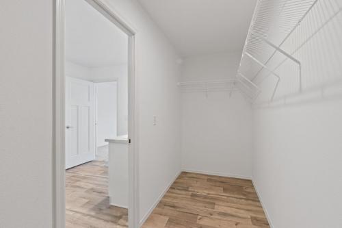 A hallway with a wooden floor and a white closet.