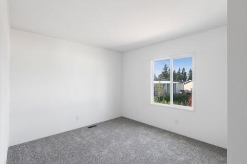 An empty room with white walls and a window.