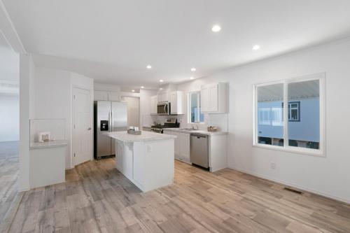 A white kitchen with wood floors and white appliances.