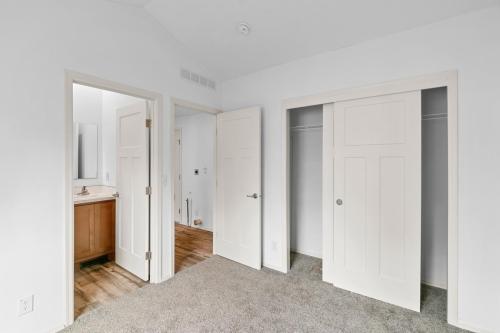 An empty room with white doors and carpet.