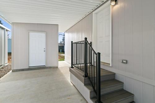 The entrance to a mobile home with stairs leading up to the front door.